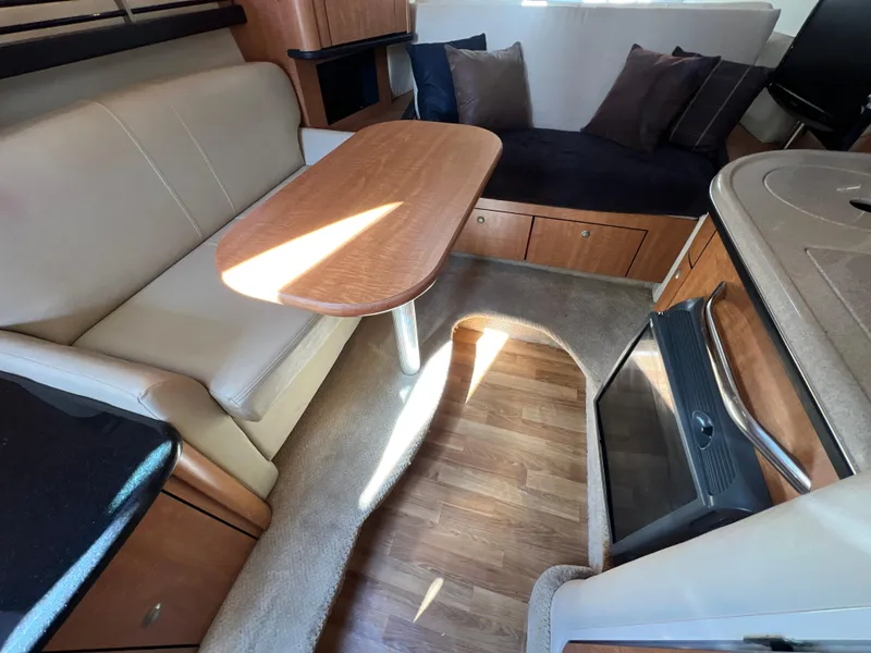 Slide: The Image of Interior of 2006 Sea Ray 290 Sundancer with seating, table, and kitchenette. - 10