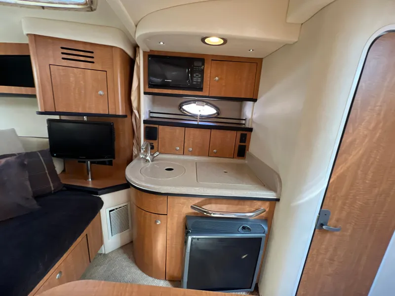 Slide: The Image of 2006 Sea Ray 290 Sundancer cabin with kitchenette, microwave, and seating area. - 12