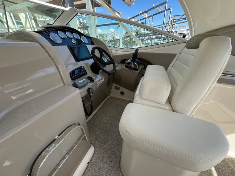 Slide: The Image of 2006 Sea Ray 290 Sundancer helm with modern controls and comfortable seating. - 22