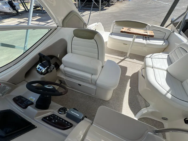 Slide: The Image of 2006 Sea Ray 290 Sundancer boat interior with helm, seating, and table. - 24