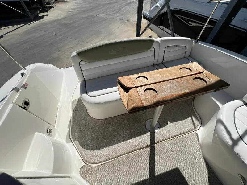 Slide: The Image of 2006 Sea Ray 290 Sundancer boat interior with seating and wooden table. - 26