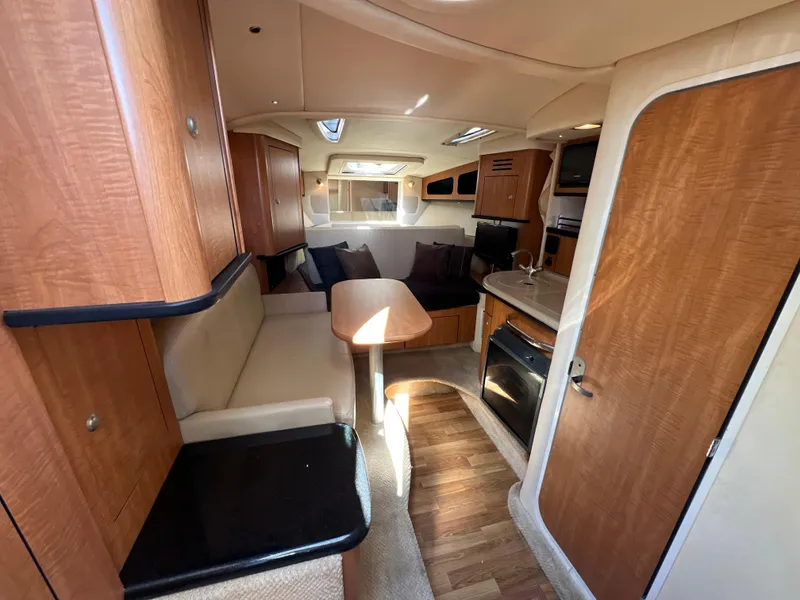 Slide: The Image of Interior of 2006 Sea Ray 290 Sundancer boat with wood finish and cozy seating area. - 5