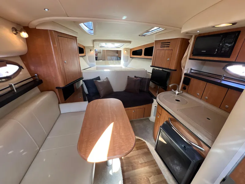 Slide: The Image of Interior of 2006 Sea Ray 290 Sundancer yacht with modern kitchen and seating area. - 6