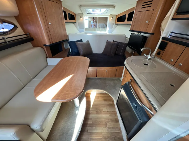 Slide: The Image of Interior of 2006 Sea Ray 290 Sundancer with kitchen, seating, and sleeping area. - 9
