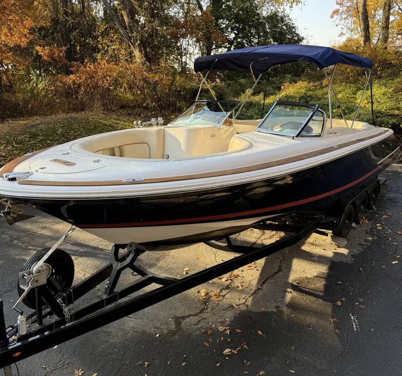 Slide: The Image of 2008 Chris-Craft Launch 28 boat on trailer, parked outdoors with autumn foliage. - 4