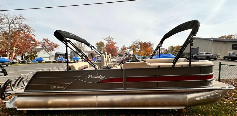Slide: The Image of 2025 Bentley Pontoons Legacy 243 Swingback, sleek design, parked outdoors with autumn trees. - 11