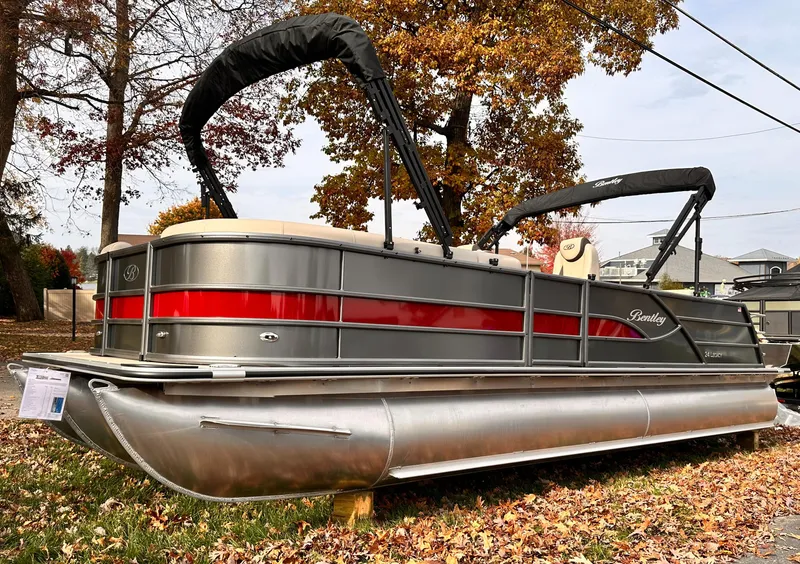 Slide: The Image of 2025 Bentley Pontoons Legacy 243 Swingback, sleek design, red stripe, parked on autumn leaves. - 4