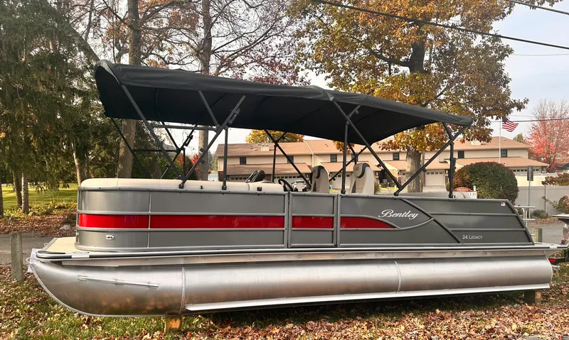 Slide: The Image of 2025 Bentley Pontoons Legacy 243 Swingback with canopy, parked on autumn leaves. - 5