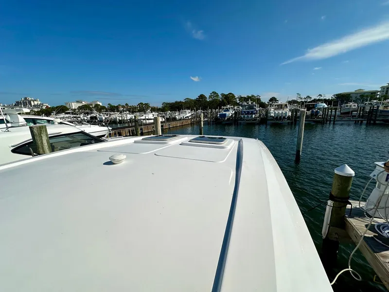 Slide: The Image of Aquila 32 Sport 2020 yacht docked at a marina under clear blue skies. - 31