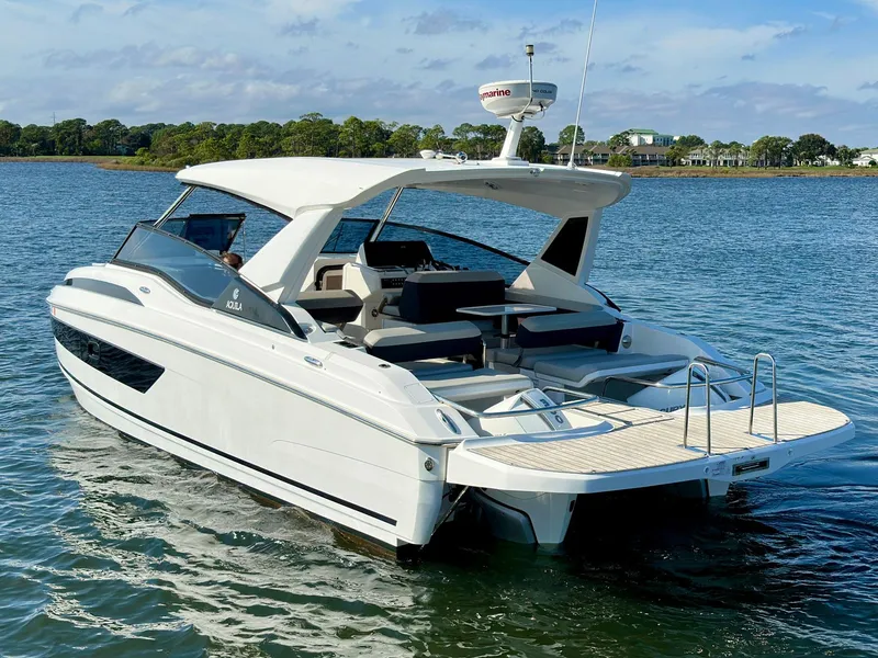 Slide: The Image of Aquila 32 Sport 2020 model luxury boat cruising on a serene lake. - 4