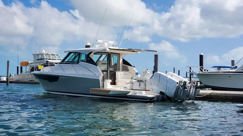Slide: The Image of 2022 Tiara Yachts 43 LE docked in a marina under a blue sky. - 3