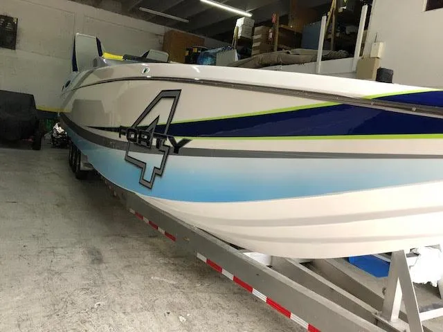 Slide: The Image of 2006 MTI 44 Pleasure Cat boat in storage, featuring sleek design and bold graphics. - 5