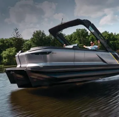 Slide: The Image of 2025 Manitou 22 Explore MAX Deck Navigator with 150hp Rotax Stealth Motor cruising on water. - 7