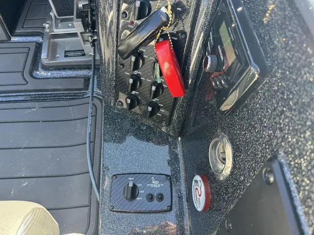 Slide: The Image of 2025 Phoenix 921 ELITE boat dashboard with controls and keychain. - 14