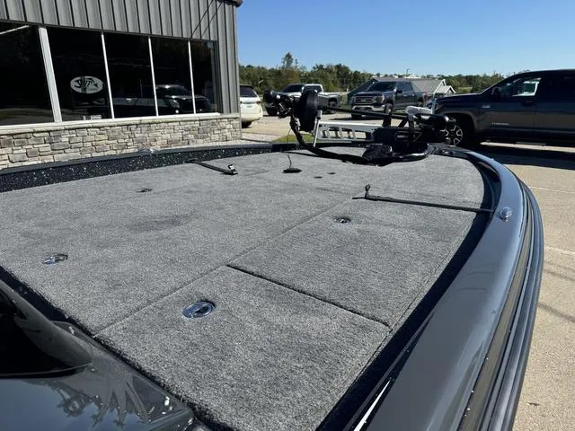 Slide: The Image of 2025 Phoenix 921 ELITE boat with spacious deck, parked outside a building. - 17