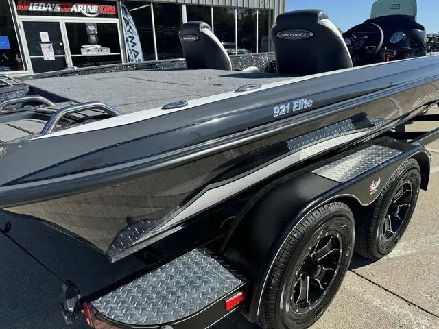 Slide: The Image of 2025 Phoenix 921 ELITE boat on trailer, sleek design, black finish, dual wheels. - 9