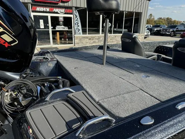 Slide: The Image of 2025 Phoenix 921 ELITE boat with spacious deck at a marine dealership. - 4