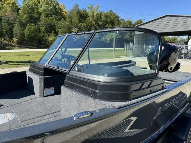 Slide: The Image of 2025 Lund 1775 Adventure Sport boat with windshield, parked outdoors. - 12