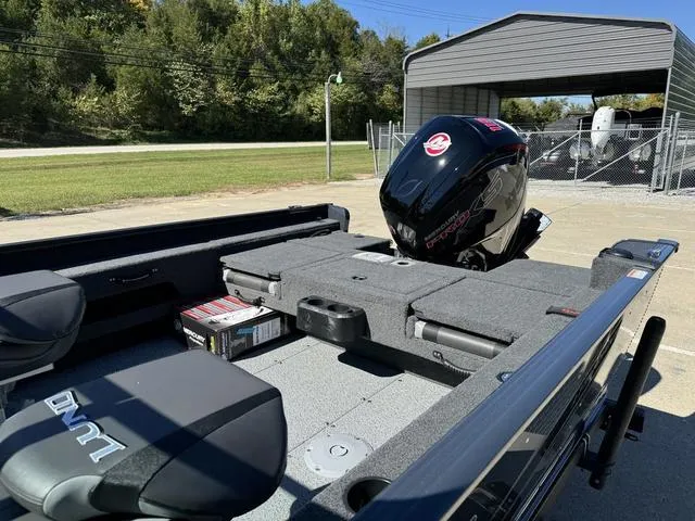Slide: The Image of 2025 Lund 1775 Adventure Sport boat with Mercury outboard motor, parked outdoors. - 13