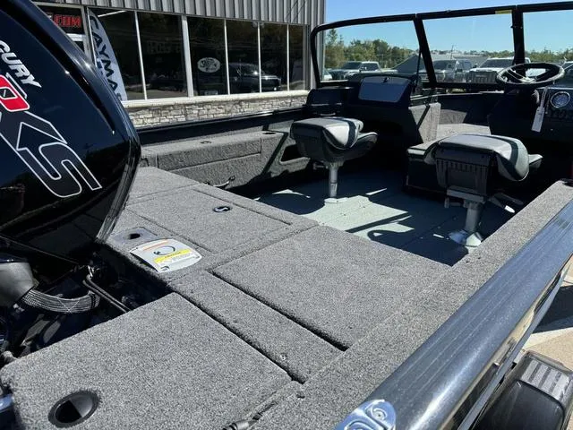 Slide: The Image of 2025 Lund 1775 Adventure Sport boat interior with seating and motor, displayed outdoors. - 4