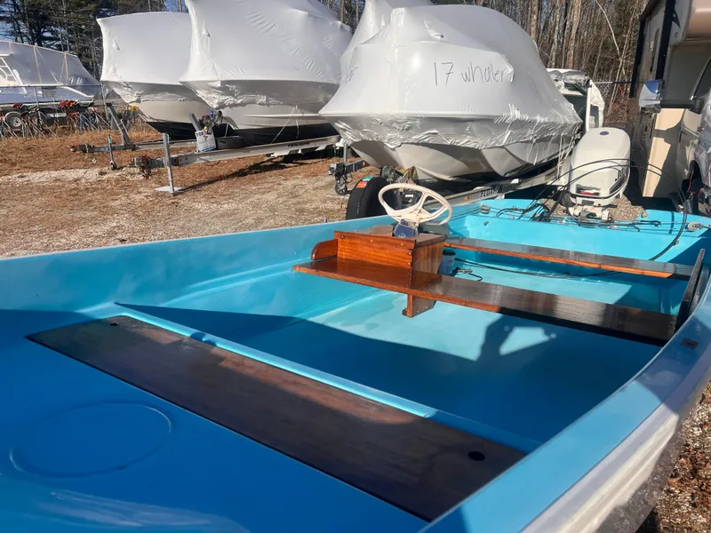 Slide: The Image of 1968 Boston Whaler 13 Sport boat with blue interior and wooden accents, parked outdoors. - 10
