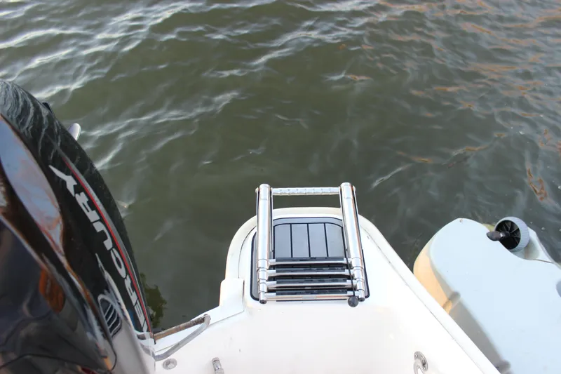 Slide: The Image of Boston Whaler 130 Super Sport 2021 boat with ladder and Mercury engine on water. - 11