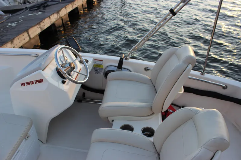 Slide: The Image of 2021 Boston Whaler 130 Super Sport boat interior with steering wheel and seating. - 12