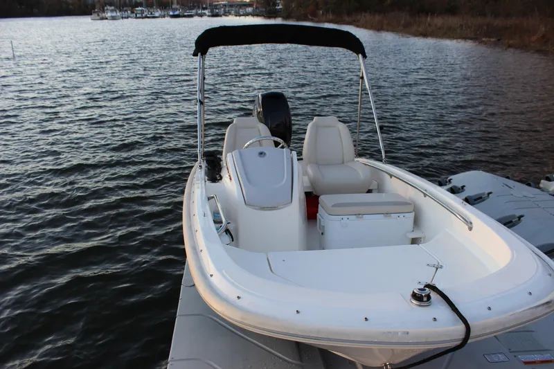 Slide: The Image of 2021 Boston Whaler 130 Super Sport boat docked on a calm lake. - 17