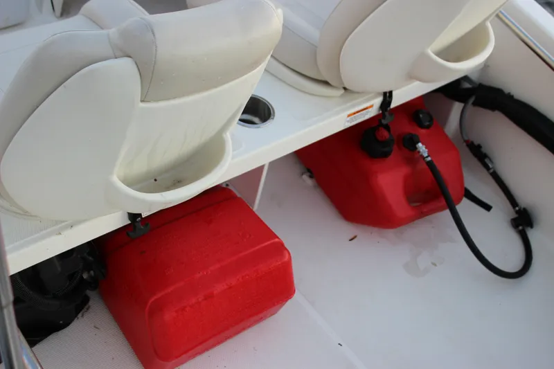 Slide: The Image of 2021 Boston Whaler 130 Super Sport interior with red fuel tanks and white seats. - 23