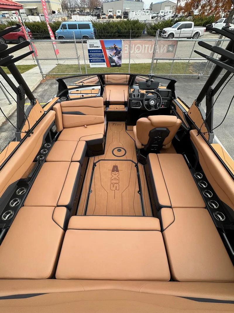 Slide: The Image of 2025 Axis Wake Research T220 boat interior with tan seating and modern dashboard. - 11
