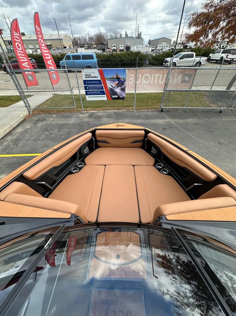 Slide: The Image of 2025 Axis Wake Research T220 boat interior with tan seating, displayed outdoors. - 12