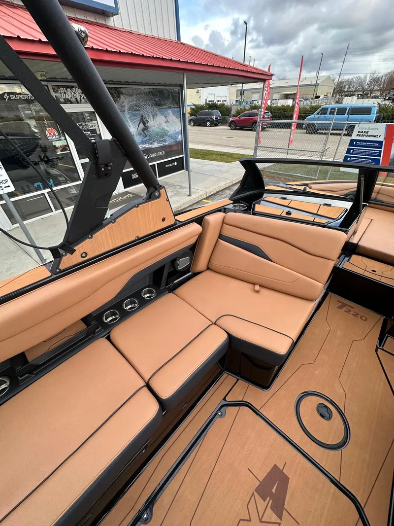Slide: The Image of 2025 Axis Wake Research T220 boat interior with tan seating and modern design. - 16