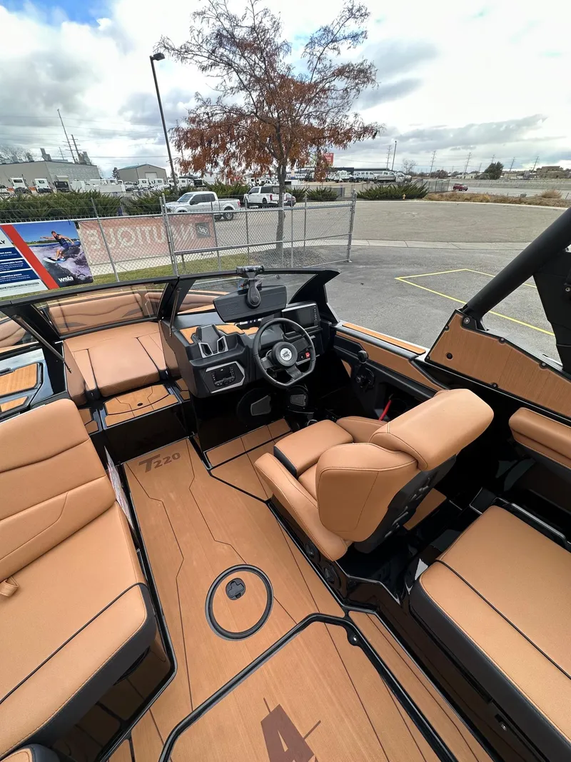 Slide: The Image of 2025 Axis Wake Research T220 boat interior with tan seating and modern dashboard. - 17