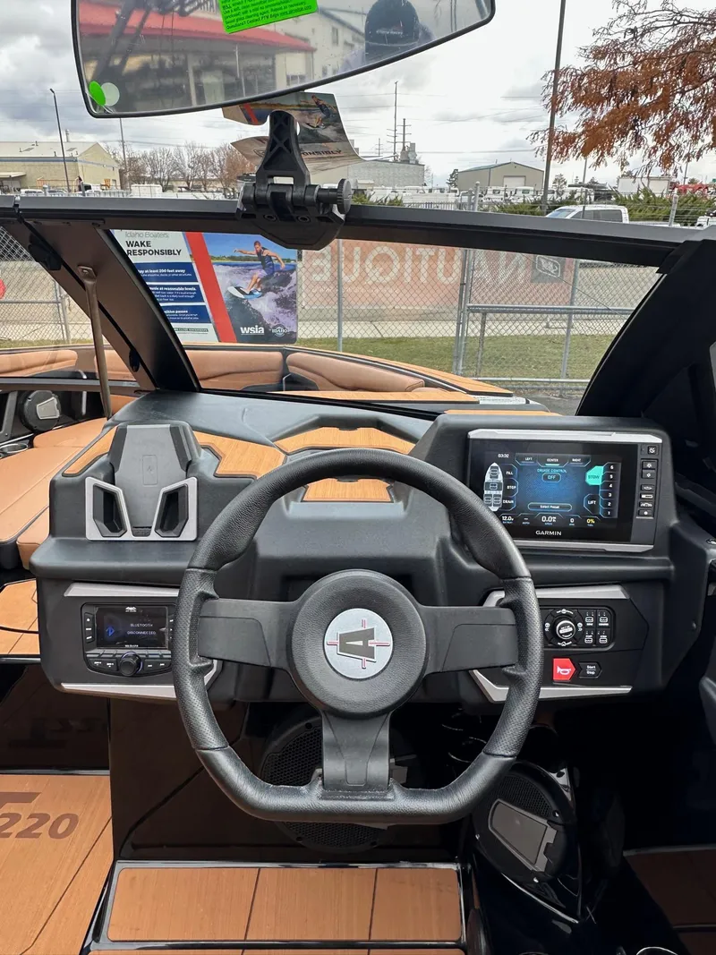 Slide: The Image of 2025 Axis Wake Research T220 boat dashboard with steering wheel and digital display. - 18
