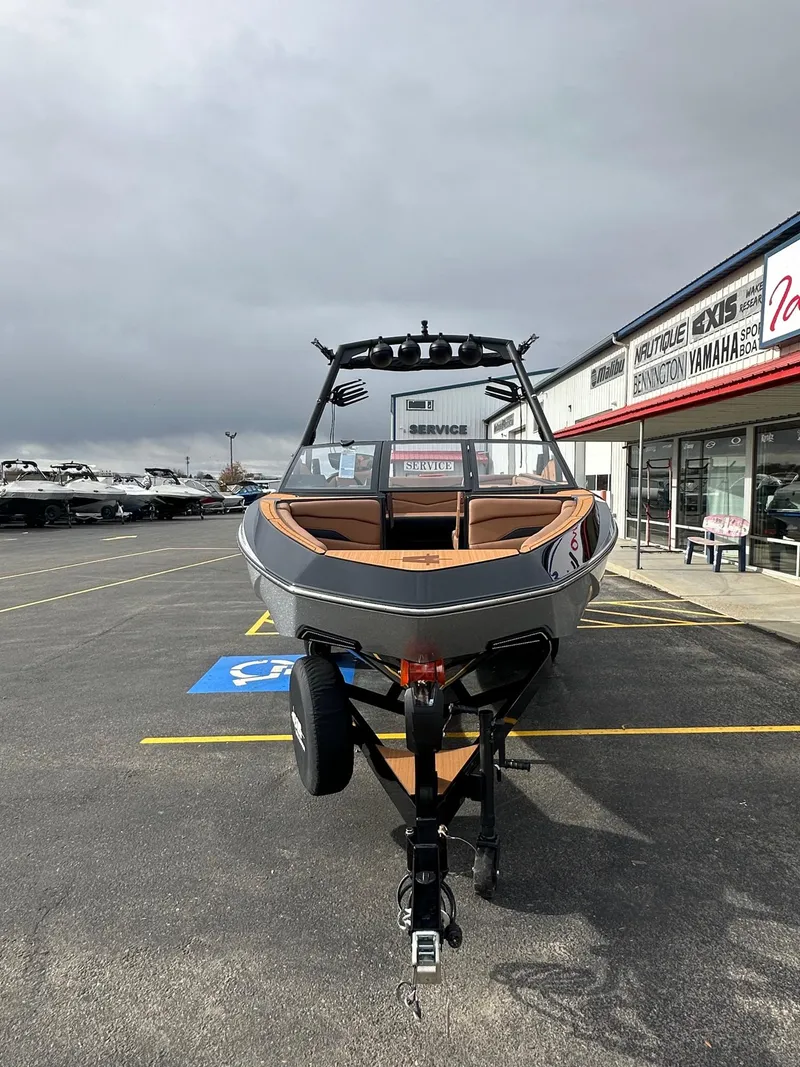 Slide: The Image of 2025 Axis Wake Research T220 boat on trailer in dealership parking lot. - 5
