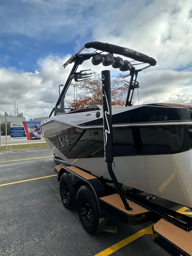 Slide: The Image of 2025 Axis Wake Research T220 boat on trailer, parked outdoors under cloudy sky. - 8