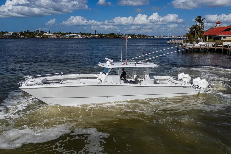 Slide: The Image of 2023 Freeman 47T boat cruising on a sunny day near a coastal town. - 5