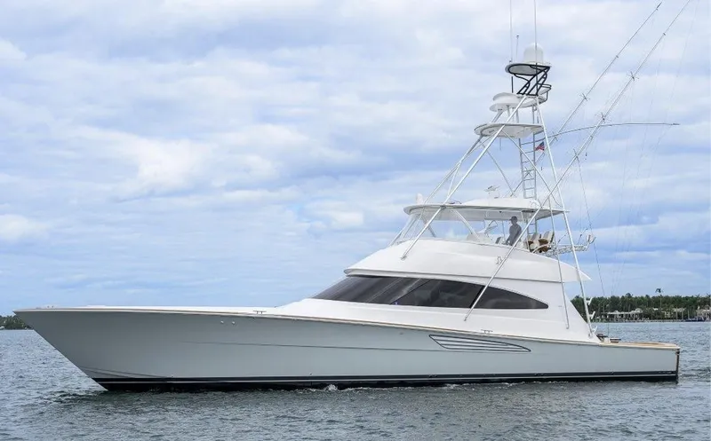 The Image of 2024 Viking 68 Convertible yacht on calm water under cloudy sky. - 0