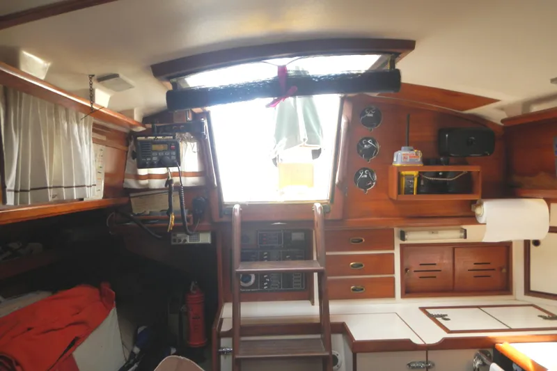Slide: The Image of Interior of 1986 Cape Dory 36 sailboat with wooden cabinetry and ladder to deck. - 13