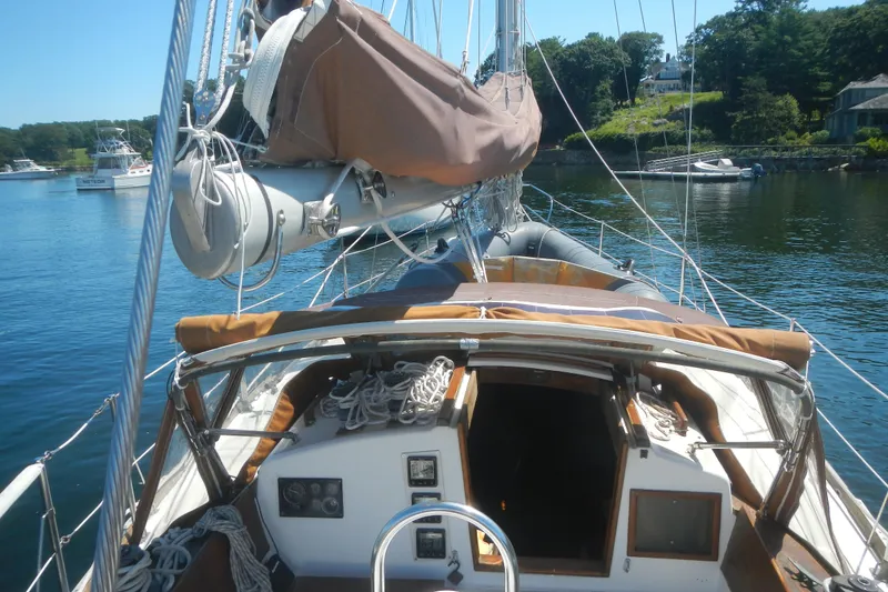 Slide: The Image of 1986 Cape Dory 36 sailboat docked, featuring deck and rigging, with scenic waterfront background. - 3
