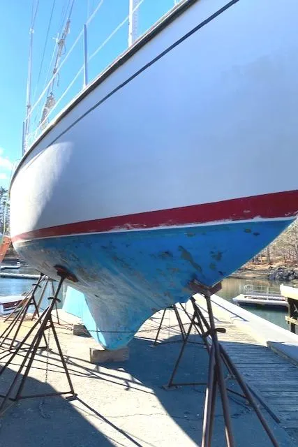 Slide: The Image of 1986 Cape Dory 36 sailboat on stands, hull view with blue and red accents. - 8