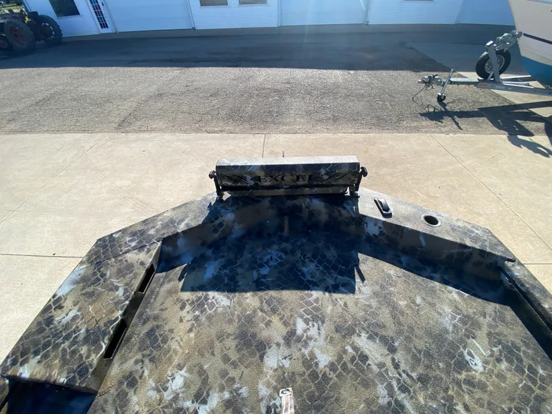 Slide: The Image of 2025 Excel 1854 F4 Shallow Water boat with camouflage design on a concrete surface. - 13