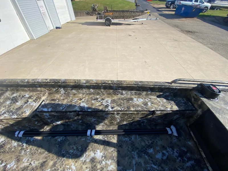 Slide: The Image of 2025 Excel 1854 F4 Shallow Water boat interior with camouflage design, parked on concrete. - 15