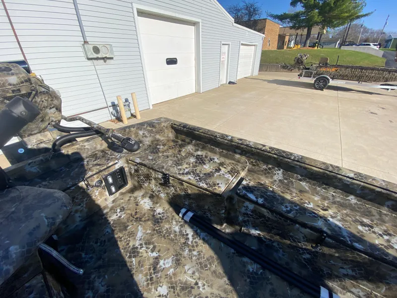 Slide: The Image of 2025 Excel 1854 F4 Shallow Water boat parked near a garage. - 19