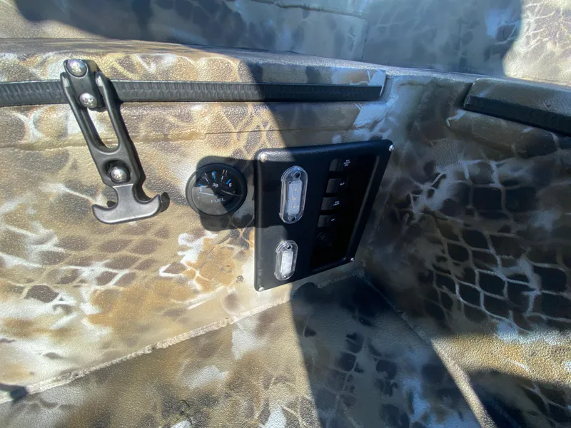 Slide: The Image of 2025 Excel 1854 F4 Shallow Water boat interior with control panel and camo design. - 22