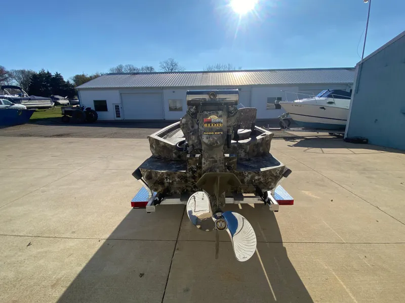 Slide: The Image of 2025 Excel 1854 F4 Shallow Water boat on trailer, rear view in sunny outdoor setting. - 3