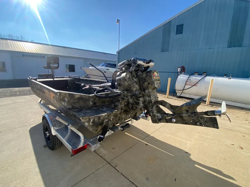 Slide: The Image of 2025 Excel 1854 F4 Shallow Water boat with camouflage design, parked outdoors. - 4