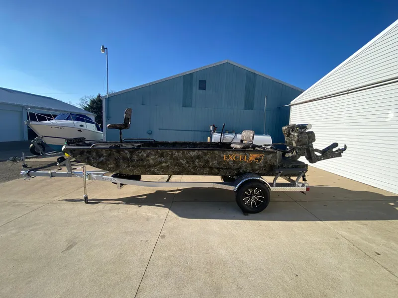 Slide: The Image of 2025 Excel 1854 F4 Shallow Water boat on trailer, parked outdoors. - 5