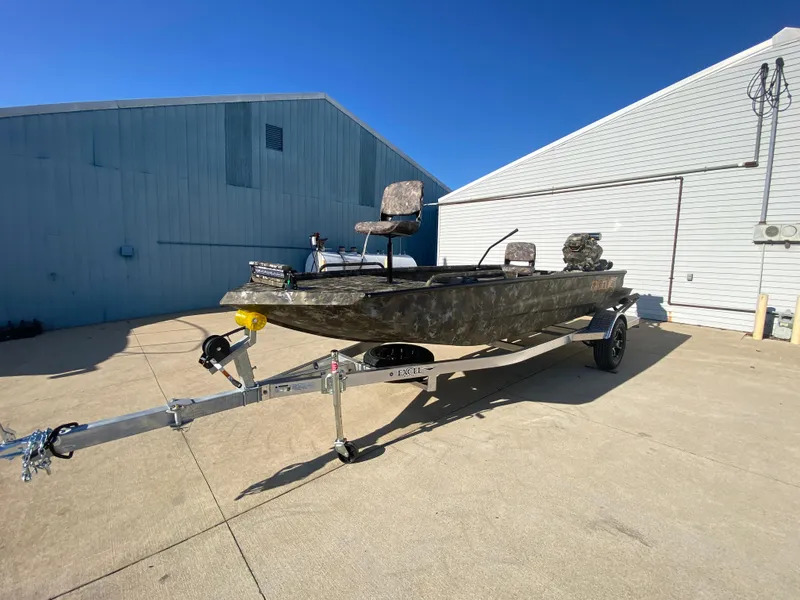 Slide: The Image of 2025 Excel 1854 F4 Shallow Water boat on trailer, parked outdoors. - 6