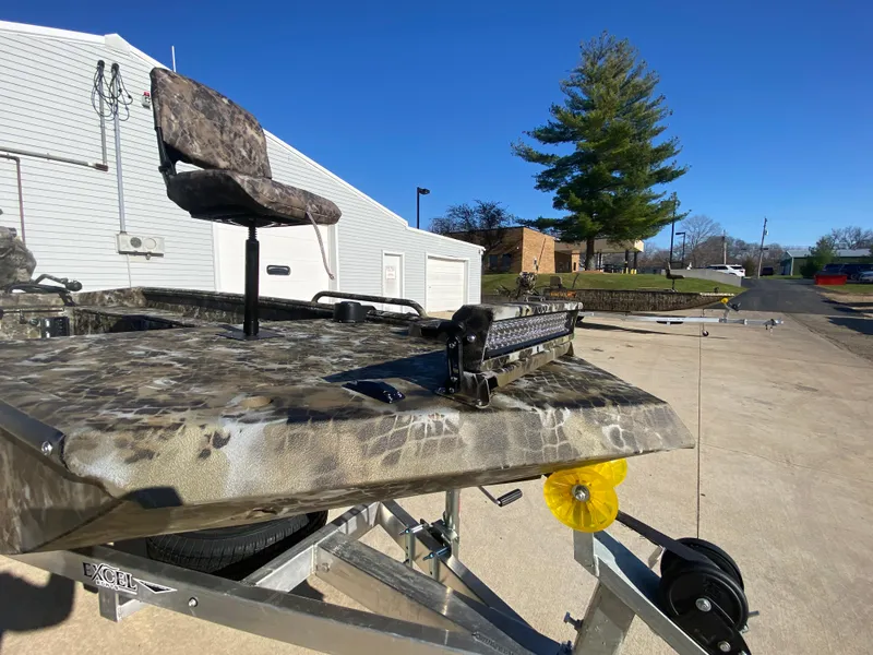 Slide: The Image of 2025 Excel 1854 F4 Shallow Water boat on trailer, camo design, sunny day. - 8